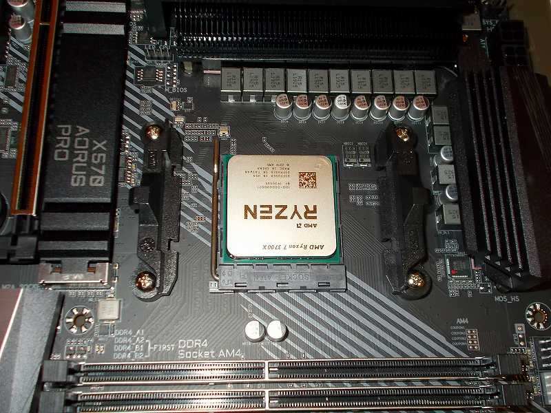 第 3 世代 Ryzen CPU（Zen 2）でこだわりの自作 PC を仮組！テストベンチ動作確認編、マザーボード GIGABYTE X570 AORUS PRO rev.1.0 に CPU AMD Ryzen 7 3700X 装着、マザーボード GIGABYTE X570 AORUS PRO rev.1.0 AM4 CPU ソケットに CPU AMD Ryzen 7 3700X を装着したらレバーを押し下げて CPU を固定